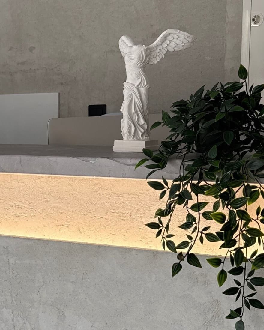 Το λευκό άγαλμα της Νίκης της Σαμοθράκης πάνω στον φωτισμένο πάγκο της υποδοχής